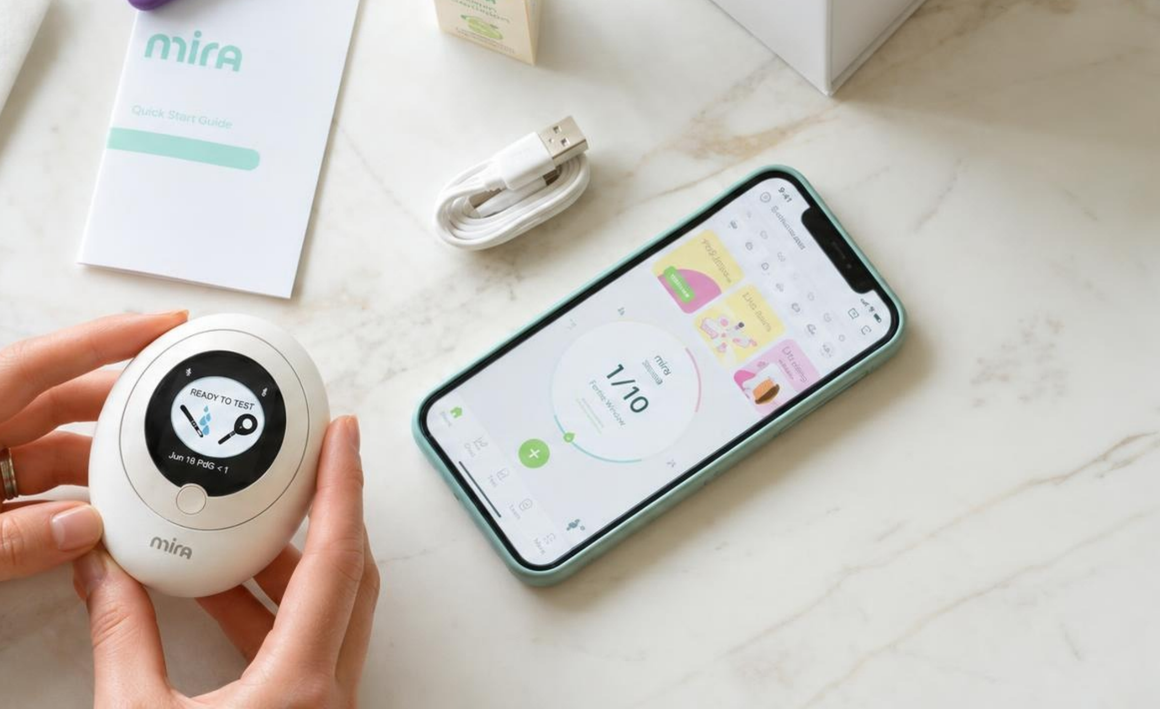 Mira monitor in hand with the Mira app open on a phone